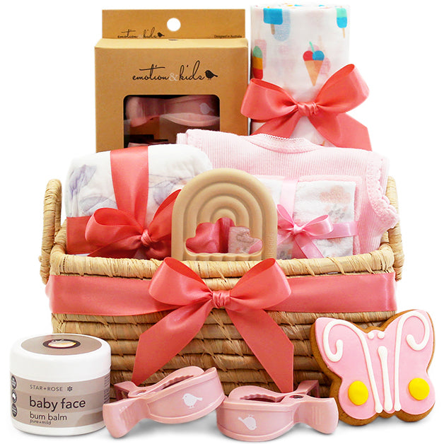 Pink baby essentials gift basket in a handmade Madagascan basket with ribbon